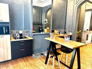 a kitchen with a wooden table and a counter top at Le Dôme in Calais