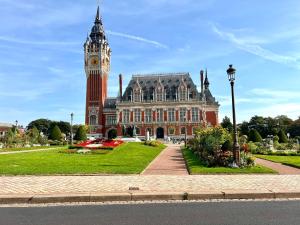 a building with a clock tower and a building with a clock at Le Dôme in Calais