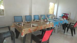 a dining room table with chairs and a table with a tableablish at KRIYA YOGA RETREAT CENTER GANGASAGAR in Dublāt