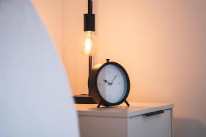 un reloj sentado en una mesa junto a una lámpara en Kelham Gate 1-Bed Apartments - City Centre - New - FREE Wi-Fi en Sheffield