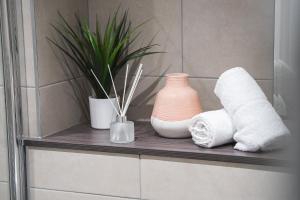 a shelf with towels and a vase and a plant at Kelham Gate 1-Bed Apartments - City Centre - New - FREE Wi-Fi in Sheffield