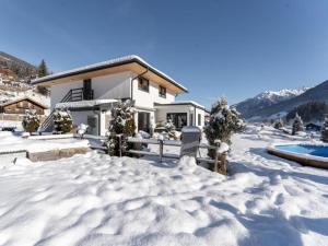 a house in the snow with a pool at Apartment Melina in Neukirchen am Großvenediger