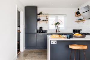 a kitchen with blue cabinets and a counter at Ashtree House in Barton on Sea