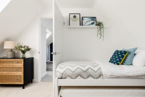 Habitación blanca con cama y espejo en Ashtree House en Barton on Sea
