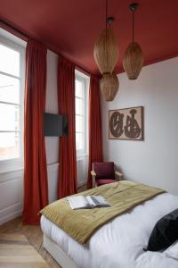 a bedroom with a bed with red walls and windows at MiHotel Blandan in Lyon