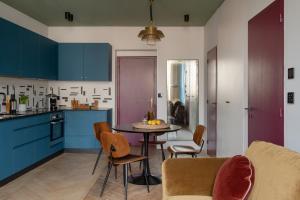 a kitchen with blue cabinets and a table and chairs at MiHotel Blandan in Lyon +28 photos