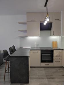 a kitchen with white cabinets and a black counter top at Apartament Parkowa in Olecko