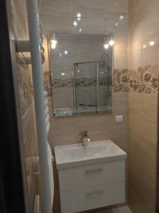 a bathroom with a sink and a mirror at Apartament Parkowa in Olecko