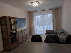 a living room with a couch and a tv at Apartament Parkowa in Olecko