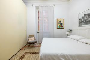 biała sypialnia z łóżkiem i krzesłem w obiekcie HospitalityRome Comfortable Apartament with Terrace w Rzymie