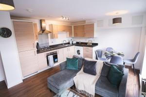 a living room with a couch and a kitchen at City Centre 2-Bed - New - Free Wi-Fi - Central in Manchester