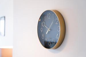 un reloj negro y dorado colgando de una pared en The Interchange - 2-Beds - Brand New - Central, en Mánchester