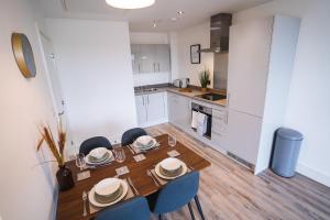 cocina y comedor con mesa de madera y sillas en The Interchange - 2-Beds - Brand New - Central, en Mánchester
