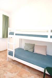 1 dormitorio con 2 literas con sábanas azules en Drago, en Agüimes