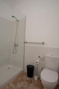 une salle de bain avec des toilettes blanches et une douche dans l'établissement Drago, à Agüimes