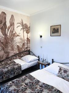 Apartments Hradný Mur في بوينيتسا: سريرين في غرفة مع لوحة جدارية على الحائط