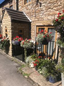 a building with flower pots on the side of it at Mistletoe Cottage in Foulridge