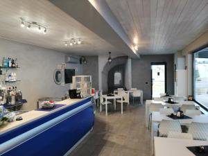 un ristorante con bancone blu e tavoli e sedie di Nautica Tarello - Casa Ena BeB a Viverone