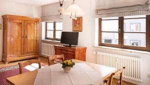 a dining room with a table and a television at Hotel Obertor in Ravensburg