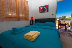 a bedroom with a blue bed with towels on it at Apartments Loncar in Jadranovo