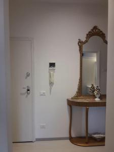 um espelho sentado em cima de uma mesa ao lado de uma porta em Appartamento vittoria em Pietra Ligure