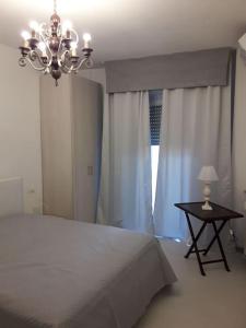 Un dormitorio con una cama y una mesa con una lámpara de araña. en Appartamento vittoria, en Pietra Ligure