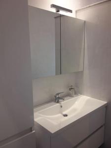 uma casa de banho branca com um lavatório e um espelho em Appartamento vittoria em Pietra Ligure
