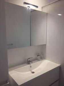 uma casa de banho com um lavatório branco e um espelho. em Appartamento vittoria em Pietra Ligure