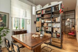 a dining room with a wooden table and bookshelves at La Design.aTA Experience Bed & Breakfast in Rome