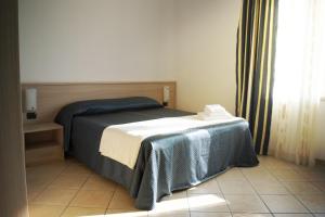 a bedroom with a bed with a table and a window at Residence La Quiete in Alba