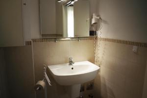 bagno con lavandino e specchio di Residence La Quiete ad Alba