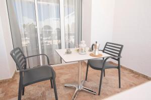 stół i 2 krzesła w pokoju z oknem w obiekcie Wohnung Esterlizia w mieście Agüimes