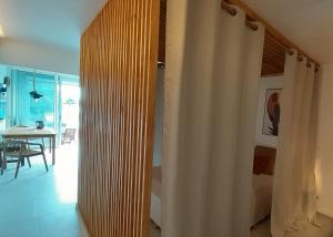 Zimmer mit einer Holzwand und einem Esszimmer mit einem Tisch in der Unterkunft Lagoon Terrace grand studio in Saint Martin