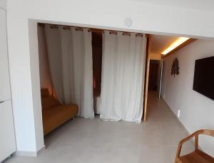 ein Wohnzimmer mit weißen Vorhängen und einem Sofa in der Unterkunft Lagoon Terrace grand studio in Saint Martin