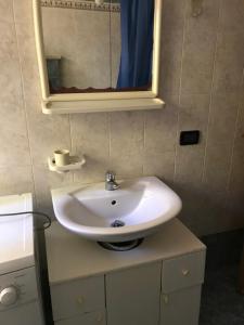 een badkamer met een witte wastafel en een spiegel bij Casa Stablum in Malè