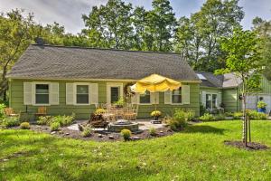 a green house with a yellow umbrella in the yard at Pittsford Trolley Home - Near Erie Canal! in Pittsford