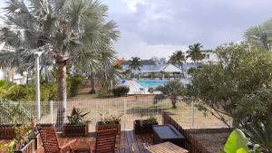ein Resort mit einem Pool, Stühlen und Palmen in der Unterkunft Lagoon Terrace grand studio in Saint Martin