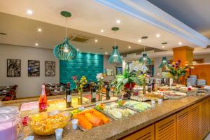 a buffet of food on a counter in a restaurant at Hotel Laghetto Viale in Gramado