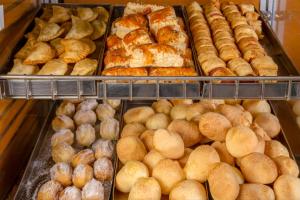 a display case filled with lots of different types of bread at Hotel Laghetto Viale in Gramado