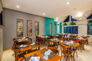 a dining room with wooden tables and chairs at Hotel Laghetto Viale in Gramado