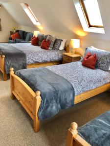 a bedroom with three beds and a couch at Cornerways B&B in Chipping Campden