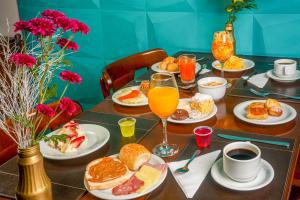 a table topped with breakfast foods and orange juice at Hotel Laghetto Viale in Gramado