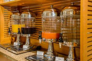 a counter with three glass blenders with orange juice at Hotel Laghetto Viale in Gramado