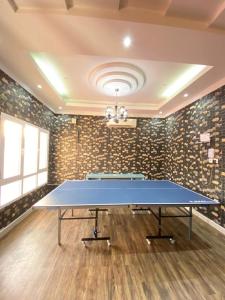 a ping pong table in a room with a wall at Pool and Steam room House in the heart of Muscat in Muscat