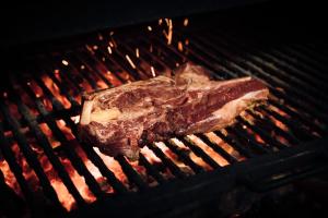 a piece of meat cooking on a grill at Hotel Avenida Benasque in Benasque