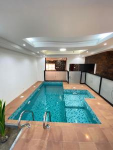 a large swimming pool in a large room with at Pool and Steam room House in the heart of Muscat in Muscat