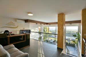 River View Apartments Hotel في براتيسلافا: غرفة معيشة مع أريكة وشرفة