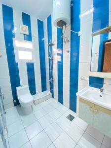 a blue and white bathroom with a toilet and a sink at Pool and Steam room House in the heart of Muscat in Muscat