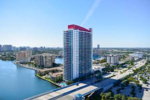 a tall building next to a body of water at Cozy 1BR Condo Beachwalk Resort in Hallandale Beach