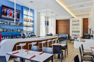 a restaurant with tables and chairs and a bar at Cozy 1BR Condo Beachwalk Resort in Hallandale Beach